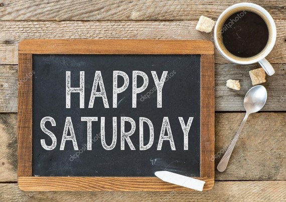 An image that has a chalk board that says happy Saturday. There's a cup of coffee in the top right corner with a spoon laying next to it.