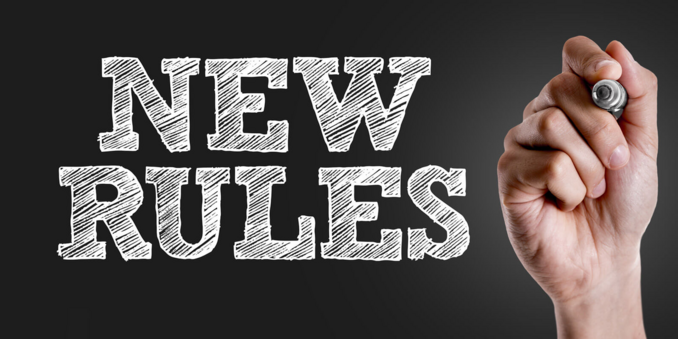 An image that has the words New Rules written with chalk on a chalkboard. There is a hand to the right with a piece of chalk or something similar.