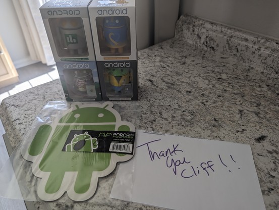 A photo of 4 Android mini figurines that I purchased along with a free Android shaped mouse pad and a thank you note!