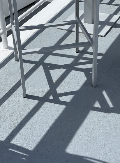 Oblique shadows on a blue-gray surface.  