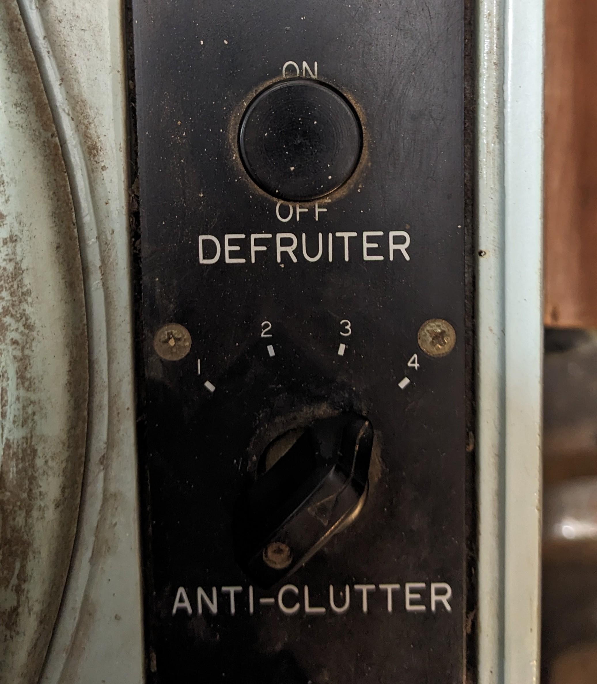 two knobs on an old machine labeled "defruiter" and "anti-clutter"