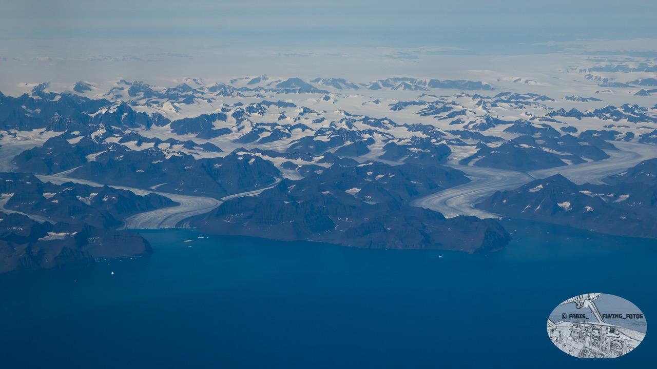 Closer view of the Greenland mountains and shore. 2 Glaciers flowing into their respective bays on the shore.