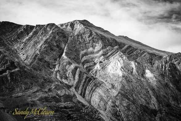 Folded sedimentation layers exposed on the side of a mountain. 