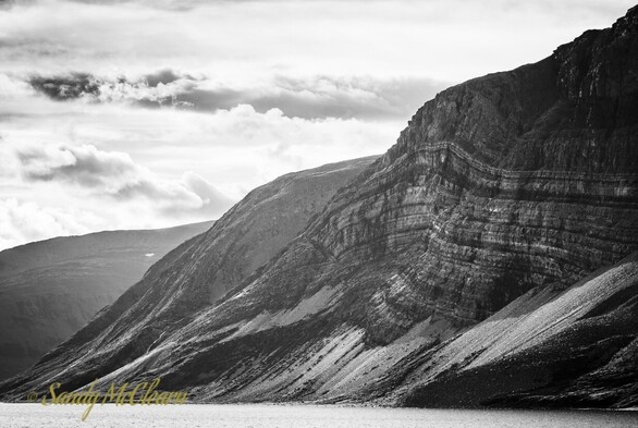 Folded sedimentation layers exposed on the side of a mountain. 