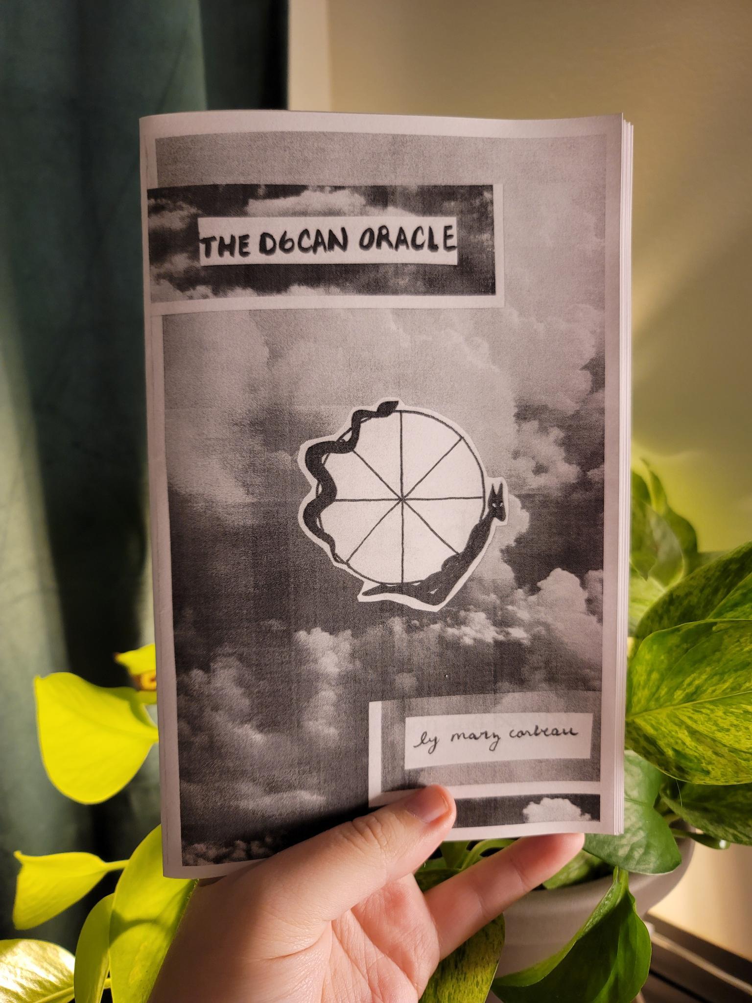 A white hand holding a black and white copy of a zine titled "the d6can oracle" in front of a backlit pothos plant. 