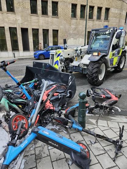 E-scooters being cleaned up by a police vehicle