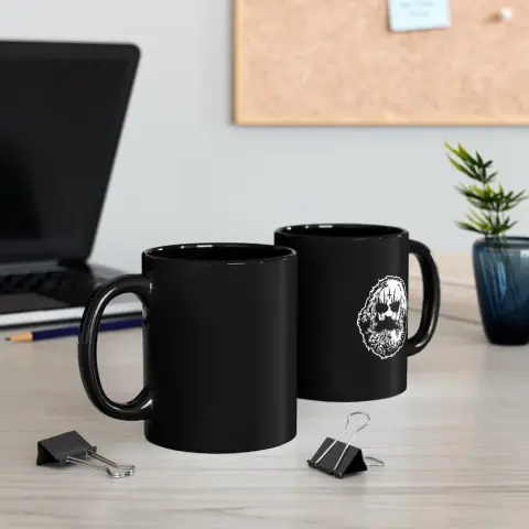 A black mug with an illustration of Karl Marx wearing corpsepaint.