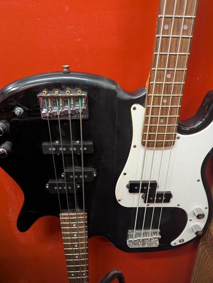 The body of a four string electric bass which seems to be attached to *another* four string electric bass pointing in the other direction