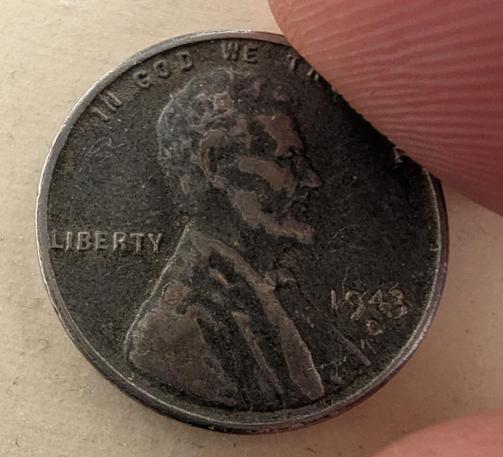 A very old penny, nearly black, held between two fingers

Close inspection shows the year 1943.

It is older than my dad. 

And apparently, ferromagnetic!