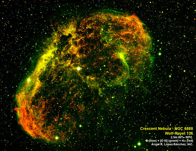 (English below) Imagen de la Nebulosa del Cuarto Creciente (NGC 6888, Crescent Nebula) obtenida por el autor combinado datos en los filtros B (azul), [OIII] (verde) y Halpha (rojo) usando la cámara WFC (Wide-Field Camera) del telescopio 2.5m INT (Isaac <br />Newton Telescope) en el Observatorio del Roque de los Muchachos (isla de La Palma, España). Se trata de una nebulosa en torno a una estrella Wolf-Rayet, denominada WR 136 (la brillante en el centro de la imagen), cuya edad es inferior a 5 millones de <br />años. Los fuertes vientos estelares de esta estrella masiva y caliente configuran esta estructura caótica y altamente inhomogénea, con filamentos y grumos de materia alrededor de la estrella central. El gas brilla (está ionizado) como consecuencia de <br />la fuerte radiación ultravioleta que recibe de la estrella Wolf-Rayet. El tamaño de la imagen es, aproximadamente, unos 22 x 22 minutos de arco, sólo un poco más pequeña que el tamaño de la luna llena (30 x 30 minutos de arco). Crédito imagen: <br />Ángel R. López-Sánchez. Image of the Crescent Nebula (NGC 6888) obtained by the author combining data using the broad-band optical B filter (blue) and the narrow-band optical filters [O III] (green) and Hα (red) obtained using the Wide Field Camera <br />(WFC) attached at the 2.5m Isaac Newton Telescope (INT) at the Roque de los Muchachos Observatory (La Palma, Spain). Located in the northern constellation of Gygnus, The Swan, it lies at around 5000 light years from us. The Crescent Nebula ...