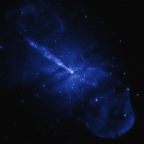 A ghostly-looking image of powerful jets of radiation coming from a galaxy. (This is Chandra’s view of the galaxy Centaurus A.) There are wispy blue bubbles in the upper left and lower right and a bright blue jet of radiation emanating from the center of the image up to the upper left.