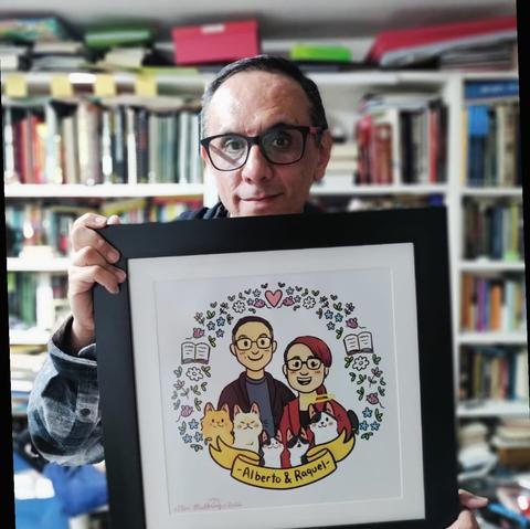 Un hombre sostiene un dibujo digital enmarcado que muestra su caricatura, la de una mujer y las de cinco gatos. Todos sonríen.