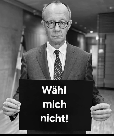 Merz im Anzug, der ein Schild hält: wählt mich nicht