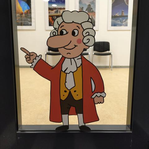 foto eines aufklebers einer gezeichneten comic-version von johann conrad schlaun mit perücke und historischer bekleidung, aufgeklebt auf eine tür mit glasscheibe