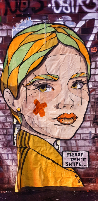 Foto mit HDR-Effekt und Vignette. 
Eine Ziegelsteinmauer mit vielen Graffitis.
Darüber ein Paste-Up im Comic-Stil von Streetartist El Bocho

Eine Frau mit gelbem Trainingsanzug-Top, gelbem Ohring und gelb-grünen Haaren und Augenbrauen. Auf der rechten Wange ein rotes Kreuz. Sie guckt den Betrachtenden an.

Unten rechts in einem weißen Textfeld mit schwarzer Schrift:

Please don't swipe...