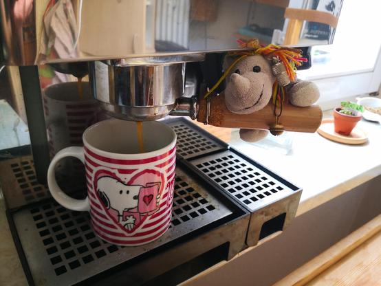 Das kleine Plüscheinhorn Carola sitzt auf dem Griff des Siebträgers unf'd passt auf, wie der Kaffee in die Tasse läuft.