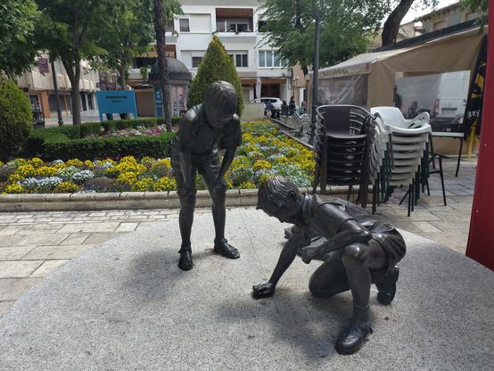 Una escultura de niños jugando a las canicas