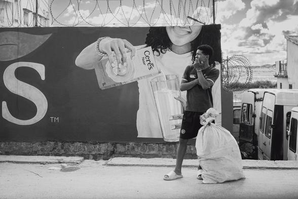 Une personne attendant le taxi-be devant une publicité pour du jus de fruit sud-africain.