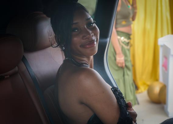 woman in black dress in backseat of car on the way to the dance
