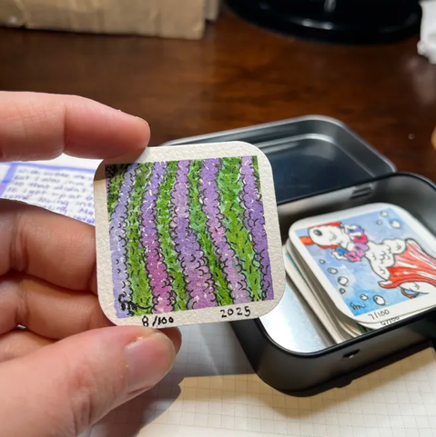 A tiny 2"x2" painting of rows of a lavender field.