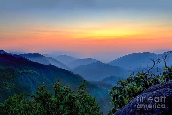 A stunning sunset with beautiful hues of pink, orange and yellow appeared over the beautiful blue ridges of the Great Smoky Mountains National Park of East Tennessee. Image by Shelia Hunt Photography.