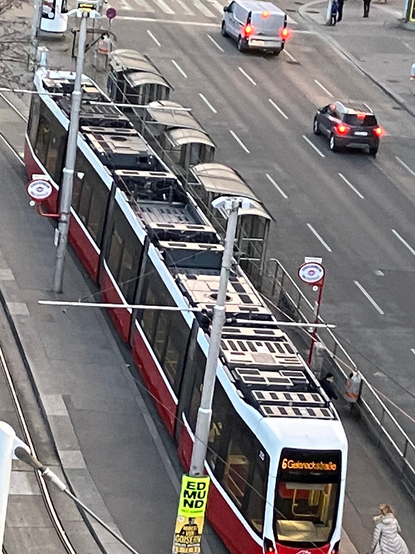 Foto zeigt links Straßenbahn von oben, daneben rechts eine 4-spurige Straße