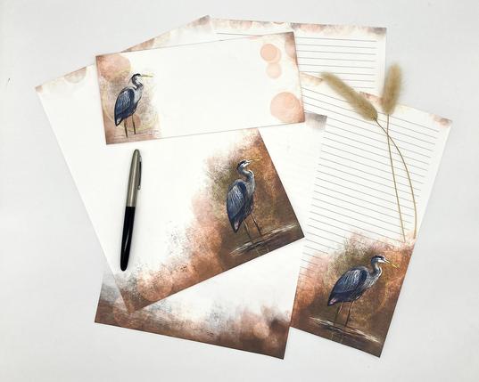 Photograph of a stack of loose leaf stationery papers featuring an illustrated heron on russet brown tones of texture.