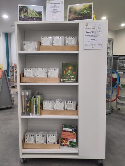 Ein Regal in der Bezirkszentralbibliothek Spandau das gefüllt mit diversen Saatgutboxen und passenden Büchern.