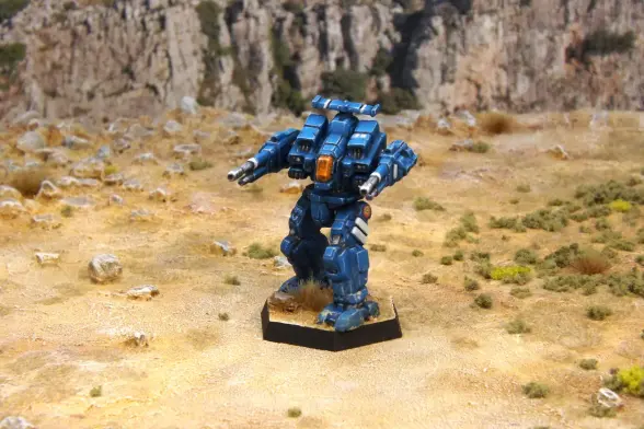 A painted miniature of a Rifleman 'Mech.  It is blue with white highlights.  The cockpit glass is orange.  The emblem of the 1st Aragon Borderers, a blue crenelated shield, is on the right leg.  The sunburst emblem of the Federated Suns is on the left hip.  The number "73" is on the left torso.  The miniature is photographed on rocky terrain.
