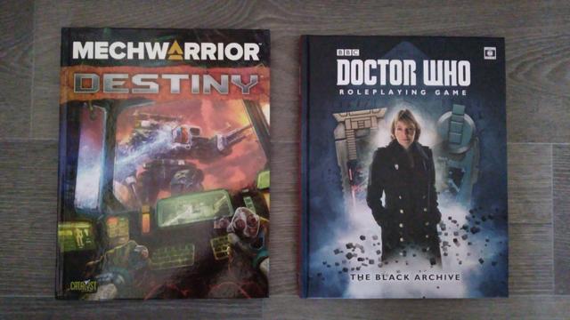 Die beiden Rollenspielbücher 'Mechwarrior: Destiny', ein Grundregelwerk auf Englisch, und 'The Black Archive', ein Quellenbuch für das 'Doctor Who Roleplaying Game', ebenfalls auf Englisch.