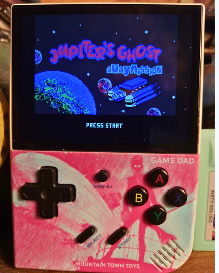 A gamedad with a pink and blue print of Filibus the Mysterious Air Pirate on it, on the screen it is running Jupiter's Ghost: Away Mission.