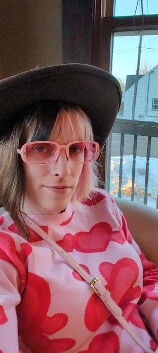 photo of me. i have split hair coloring, with black on the left and pink on the right. i'm wearing a stetson, pink sunglasses, and a pink sweater with red hearts on it.