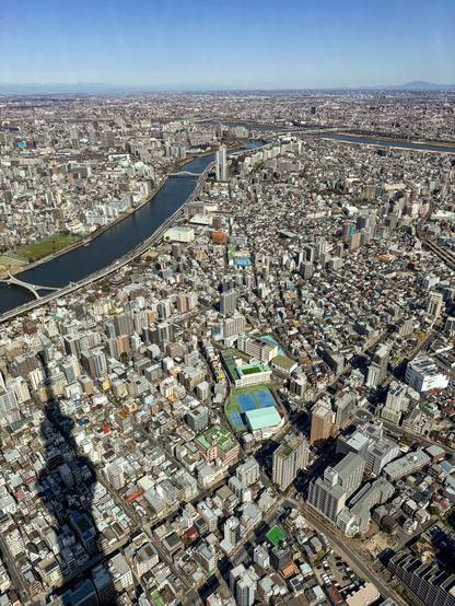 View of dense urban development with the shadow of the observation tower cast upon the cityscape