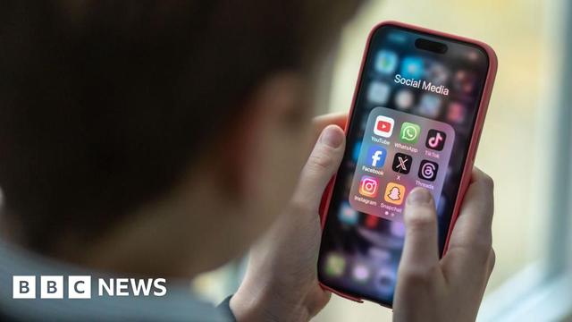 A 12-year-old boy looks at an iPhone screen showing various social media apps including TikTok, Facebook and X on 25 February 2024.