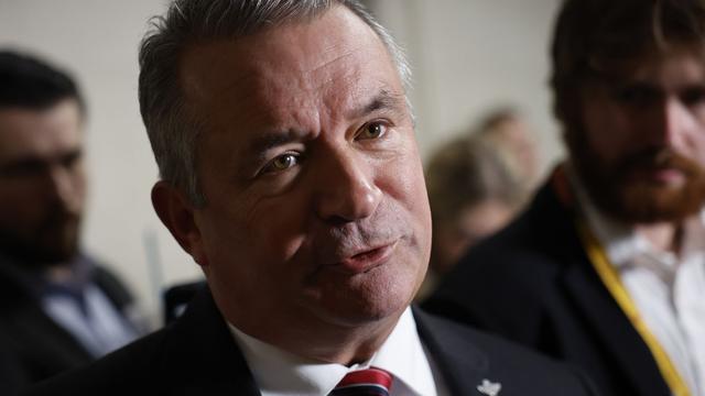 Rep. Don Bacon, wearing a gray suit and speaking to reporters.