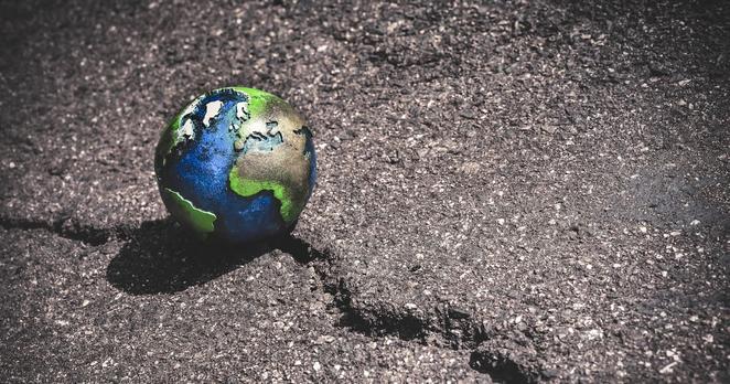Erdkugel auf einem Riss im Boden, Symbolfoto Klimawandel und Klimakatastrophe
