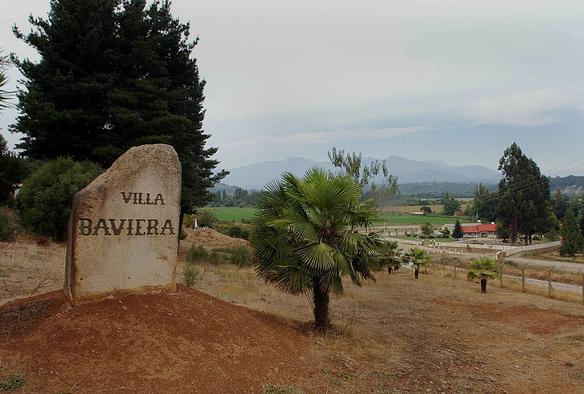 Auf einem Feldstein vor einem großen Gelände steht der Schriftzug "Villa Baviera"
