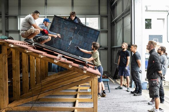 Mehrere Personen bastel an einem Solarmodul. Mehrere Personen bastel an einem Solarmodul.