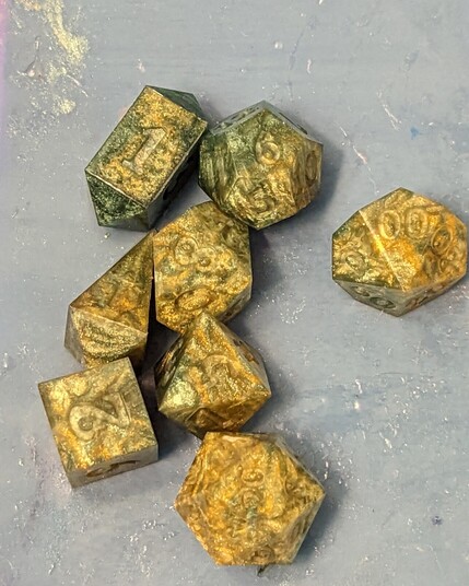 A set of roleplaying dice that are a frankly ugly swirl of green and yellow that looks a bit like baby poo