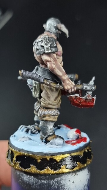 Slaughterpriest miniature standing on a snow base with two bloody axes 