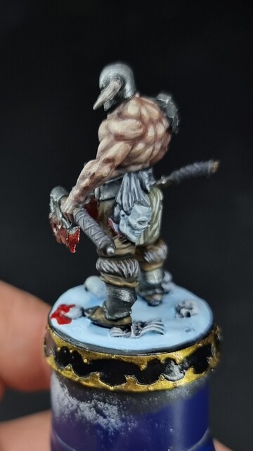 Slaughterpriest miniature standing on a snow base with two bloody axes 