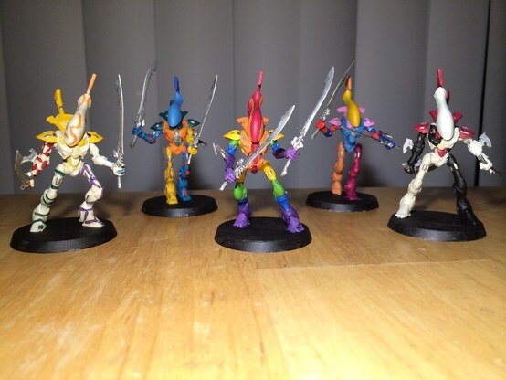 Warhammer 40K Miniatures

Five painted wraithblades with twin swords. 

One white with yellow stripes

One blue and orange

One rainbow

One yellow pink and blue

One white red and black 

