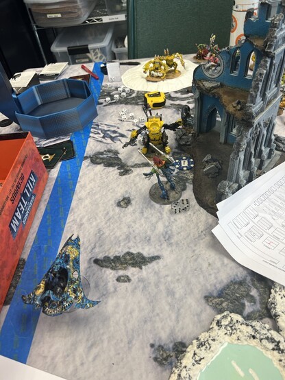 Warhammer 40K Battle

Left flank of snow battlefield. Yellow little stompa fighting a rainbow Wraithlord over an objective by some ruins. 

Yellow killer kans in the background on a crater. 

Voidweaver with starry night pattern in foreground. 