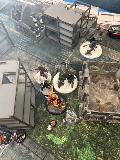 Warhammer 40K Battle

Avatar of Khaine fighting a small knight and two war suits. Wraithblades lurk around the corner of a building. Second knight behind the melee. Squad of sisters and a chariot lurking in ruins holding a back field objective. 