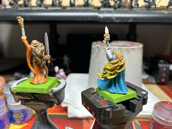 Two Damsel minis for Warhammer The old world, one in orange dress and the other a blue cloak and white dress. Both are armed with magical items and swords.