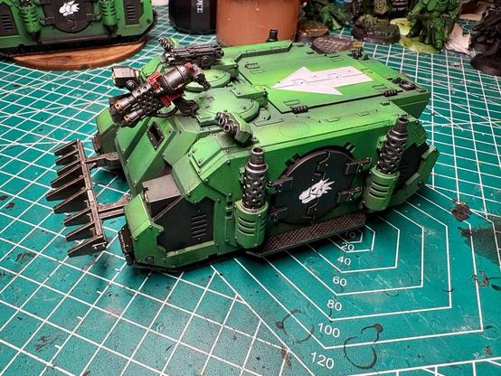 The right side of the rhino. The main armories is green; accent armor is black. The salamander sigil is on the side door. A white tactical arrow symbol is on the top hatch. The heavy flamer is red. 