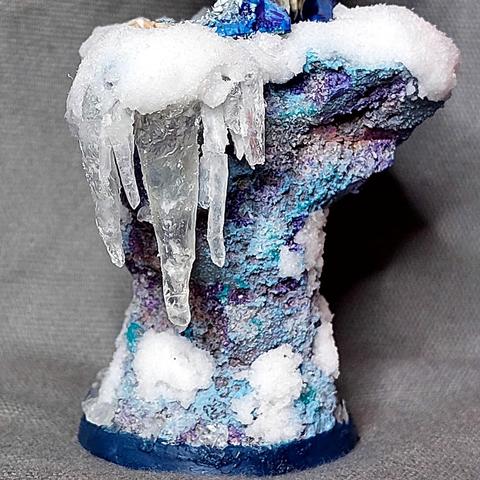 Fedipaint entry decorative base: hourglass shaped piece of rock in blues and reds and purples and with fake snow and icicles