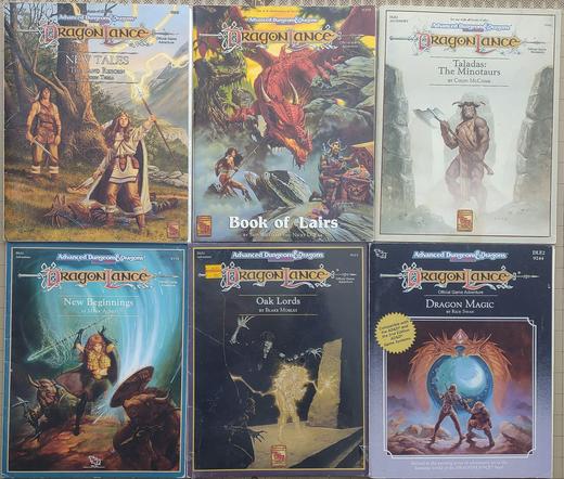 DragonLance New Tales The Land Reborn: a woman dressed in buckskin with a bloody dagger and a glowing staff stands over the body of a draconian. A man in a buckskin tunic stands under a tree behind her.

DragonLance Book of Lairs; A huge red dragon climbs over a rocky ridge towards a woman with a spear and shield. A man in a horned helmet is looking into a chest filled with treasure with his back to the dragon.

Taladis: The Minotaurs: A minotaur wearing a quilted tunic and wielding a very large two-headed axe stands ready between two rock cliffs.

New Beginnings: a woman with a glowing staff fights two scruffy-looking minotaurs.

Oak Lords: Two odd skeletal creatures stand near an obelisk with a tree engraved in it. An elf seems to be caught in a spell coming from the obelisk.

Dragon Magic: a dwarf and a human watch a globe framed with a carving of two dragons with a gem between their heads rising over the landscape.