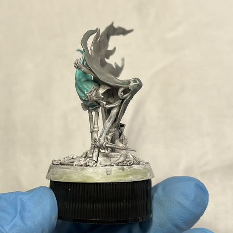 Myrmourn Banshee model with a mid-grey mask and cape and light teal dress, looking at the model's face to show the mask and cape colors