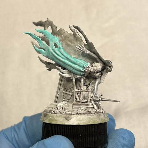 Myrmourn Banshee model with a mid-grey mask and cape and light teal dress, looking at the model's torso to show the skirt color
